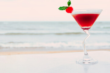 Summer cocktail with tropical beach on background.
