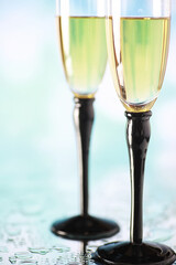Naklejka premium Background with tall glasses for sparkling wines. Champagne and spray in glass glasses. Celebratory drink with reflection.