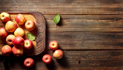 Obraz na płótnie Canvas Red apple and wooden board on rustic wooden background with copy space. Summer or autumn season.