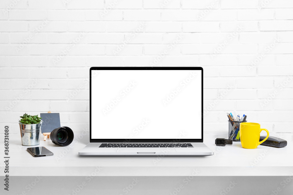 Poster Modern laptop computer on work desk with isolated screen for mockup, app or web site promotion. Clean desk with cup of coffee and plant
