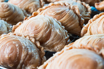 Curry puff. Close up the curry puff stack on the strainer after fried. Asian food cuisine.