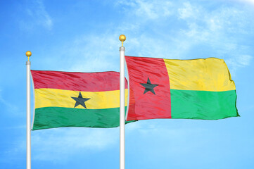 Ghana and Guinea-Bissau two flags on flagpoles and blue sky