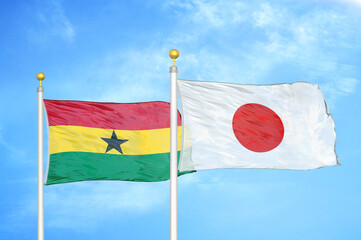 Ghana and Japan two flags on flagpoles and blue sky