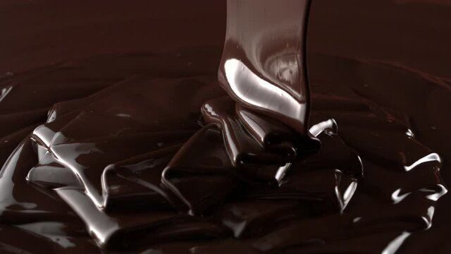 Rotation of chocolate pouring down with swirl in slow motion 4k