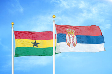 Ghana and Serbia two flags on flagpoles and blue sky