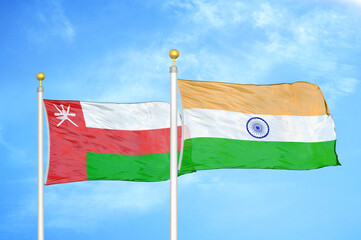 Oman and India two flags on flagpoles and blue sky
