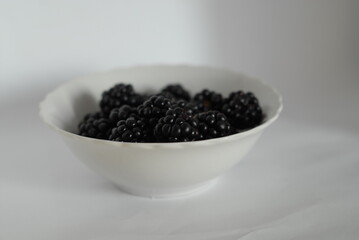 Fototapeta na wymiar white bowl of blackberries