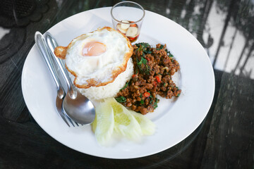 Thai stir-fried pork andfried egg and basil served with rice,Fried Basil with Pork Chop