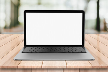 Laptop with blank screen on wooden table with bokeh restaurant backgound