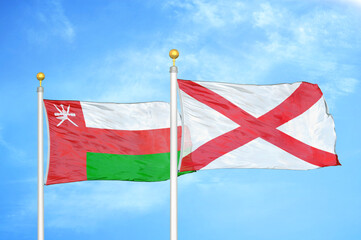 Fototapeta na wymiar Oman and Northern Ireland two flags on flagpoles and blue sky