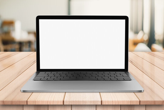 Laptop with blank screen on wooden table with bokeh restaurant backgound