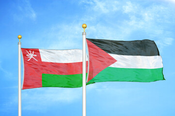 Oman and Palestine two flags on flagpoles and blue sky