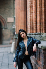 Portrait of beautiful young blonde woman wearing stylish black outfit, she smiling on urban background, happy time, Travel Concept.trendy girl in stylish sunglasses ad leather jacket in the street.