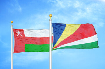 Oman and Seychelles two flags on flagpoles and blue sky