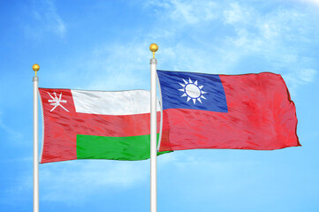 Oman and Taiwan two flags on flagpoles and blue sky