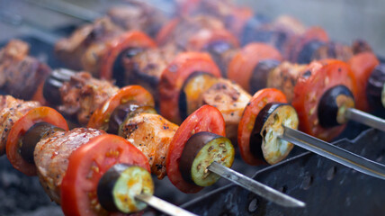 Juicy shish kebab in the grill outdoors, pieces of meat on coals, close-up. Smoke, blurred bokeh...