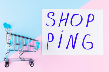 Shopping cart on blue background. Shop trolley at supermarket. Sale and discount. Consumer society...