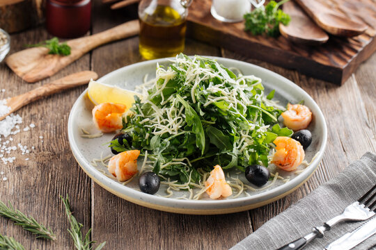 Fresh arugula salad with shrimps and olives