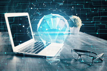 Computer on desktop in office with bulb icon hologram. Multi exposure. Concept of idea.