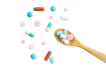 Assorted pharmaceutical medicine pills in a wooden spoon. White background.