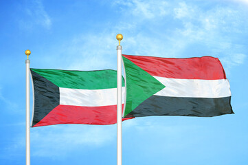 Kuwait and Sudan two flags on flagpoles and blue sky