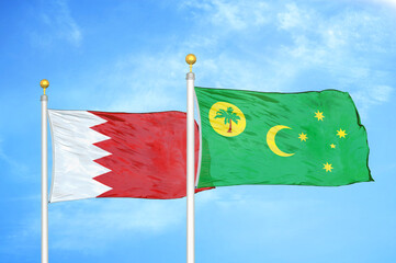 Bahrain and Cocos Keeling Islands two flags on flagpoles and blue sky