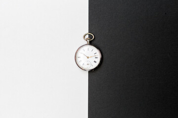 Vintage watch on black and white paper, day and night concept