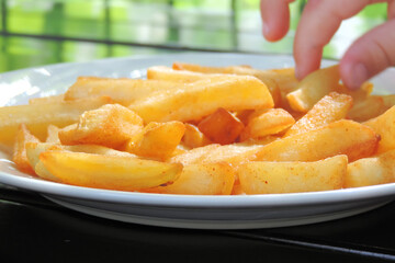 French fries, slices in a plate and sun glare