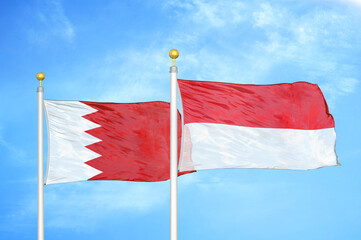 Bahrain and Indonesia two flags on flagpoles and blue sky