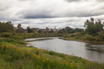 Fototapeta na wymiar Summer landscape with river and clouds. Small russian town