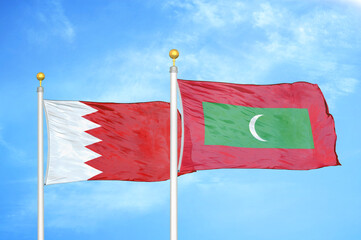 Bahrain and Maldives two flags on flagpoles and blue sky