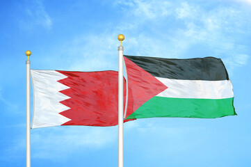Bahrain and Palestine two flags on flagpoles and blue sky