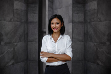 Portrait of a Smiling Mixed Races Business Woman, Crossed Arm and Look into the Camera