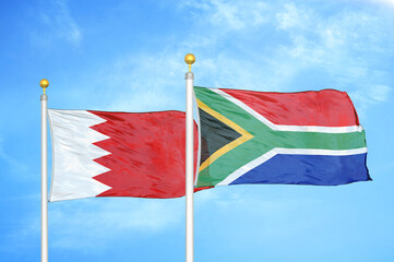 Bahrain and South Africa two flags on flagpoles and blue sky