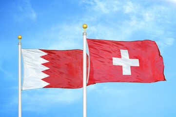 Bahrain and Switzerland two flags on flagpoles and blue sky