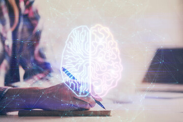 Multi exposure of woman's writing hand on background with brain hud. Concept of learning.
