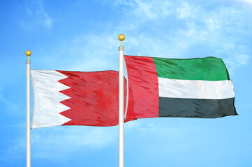 Bahrain and United Arab Emirates two flags on flagpoles and blue sky