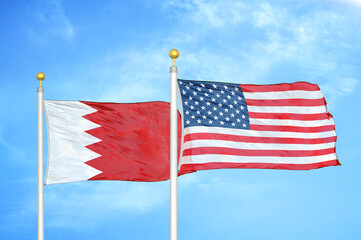 Bahrain and United States two flags on flagpoles and blue sky