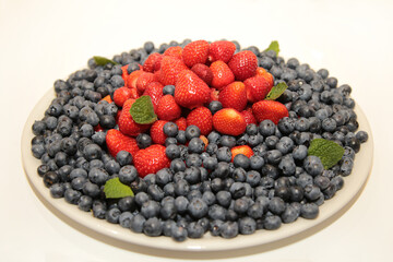 Blueberries with strawberries and mint leaves.