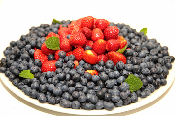 Blueberries with strawberries and mint leaves.