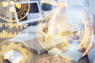 Tech theme hologram over woman's hands taking notes background. Concept of hightech. Double exposure