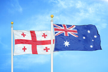 Fototapeta premium Georgia and Australia two flags on flagpoles and blue sky