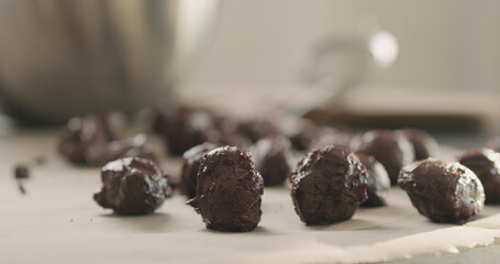 young woman making chocolate truffles on home kictchen