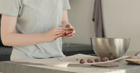 Obraz na płótnie Canvas young woman making chocolate truffles on home kictchen