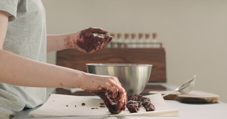 young woman making chocolate truffles on home kictchen