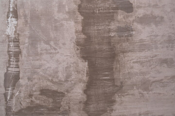 Raw old cement or concrete or plaster wall with stains and cracks for background and texture.