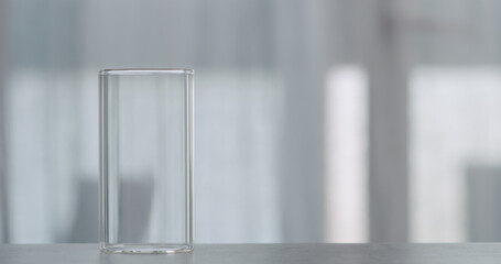 empty glass on concrete countertop with window on background