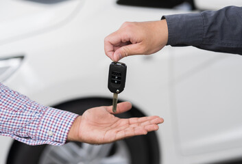 Young man buy the new car. Businessman giving a car key. Salesman car dealing success with customer.