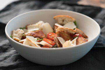 Fresh caesar salad with chicken and cherry tomatoes in white bowl