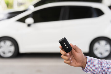 Close up car keys and remote control car alarm systems hold in hand. Young man buy the new car.